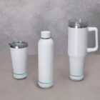 Three white drink containers: a tumbler, a bottle, and a travel mug with a handle.