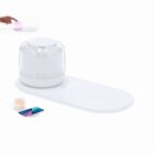 White wireless charging pad with a glass diffuser; a phone is charging beside it.