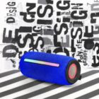 Blue portable speaker with LED strip on a striped surface, graphic design text in background.