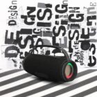 Black portable speaker with colored lights, on a striped surface, with design text background.