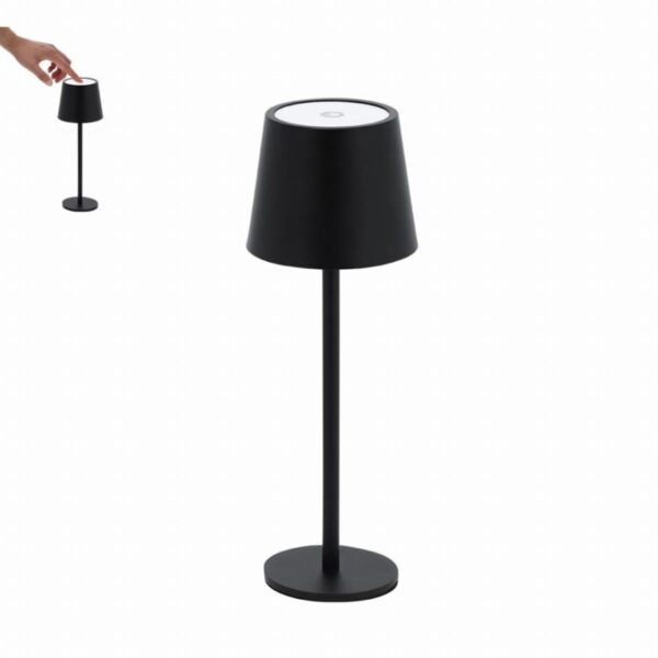 A hand reaching to touch the top of a modern black table lamp with a round base.