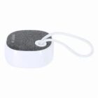 Small, square, portable speaker with a fabric top and a white carrying loop.