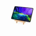 A tablet with a colorful screen displayed on a small wooden easel.