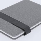 Gray fabric-covered notebook with a black elastic band closure on a light background.