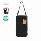 Black recycled cotton shoulder bag with a tag, shown on its own and worn by a person.