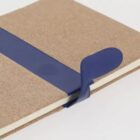 Notebook with a blue elastic strap and a brown cardboard cover.