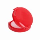 Red round compact powder case, open with white powder inside.