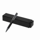 A black pen with silver accents rests on a closed black box.