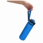 Hand holding a blue water bottle by a strap, isolated on a white background.