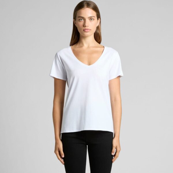 Person in a white V-neck T-shirt and black pants against a plain background.