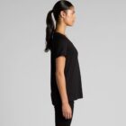 Woman in black t-shirt and pants standing in profile against a plain gray background.