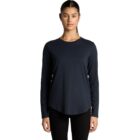 Woman in black long-sleeve shirt and pants standing against a white background.