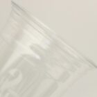 Close-up of a transparent plastic cup on its side against a pale background.