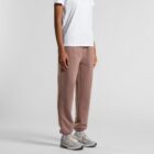 Person in a white shirt and brown sweatpants with gray sneakers on a white background.