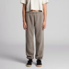 Person in beige crop top and gray sweatpants standing against a plain background.