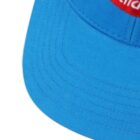 Close-up of a blue baseball cap with red and white logo on the front.