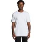 Man wearing a plain white t-shirt and black pants standing against a white background.