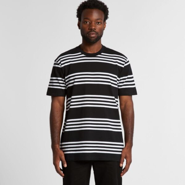 Man wearing a black T-shirt with horizontal white stripes, standing against a plain background.