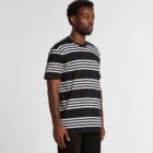 Man wearing a black t-shirt with white horizontal stripes, standing against a plain background.
