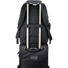 Black backpack attached to the handle of a black suitcase.