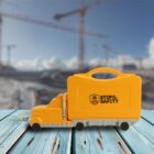 Yellow toy truck with a safety message on blue wooden surface; construction site background.