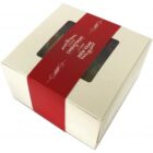 Cream gift box with red band that says Christmas & New Year and a clear window on top.