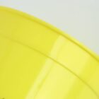 Close-up of a bright yellow plastic plate, showing its curved edge against a pale background.
