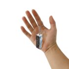Hand holding a keychain with a patterned block pendant on a white background.