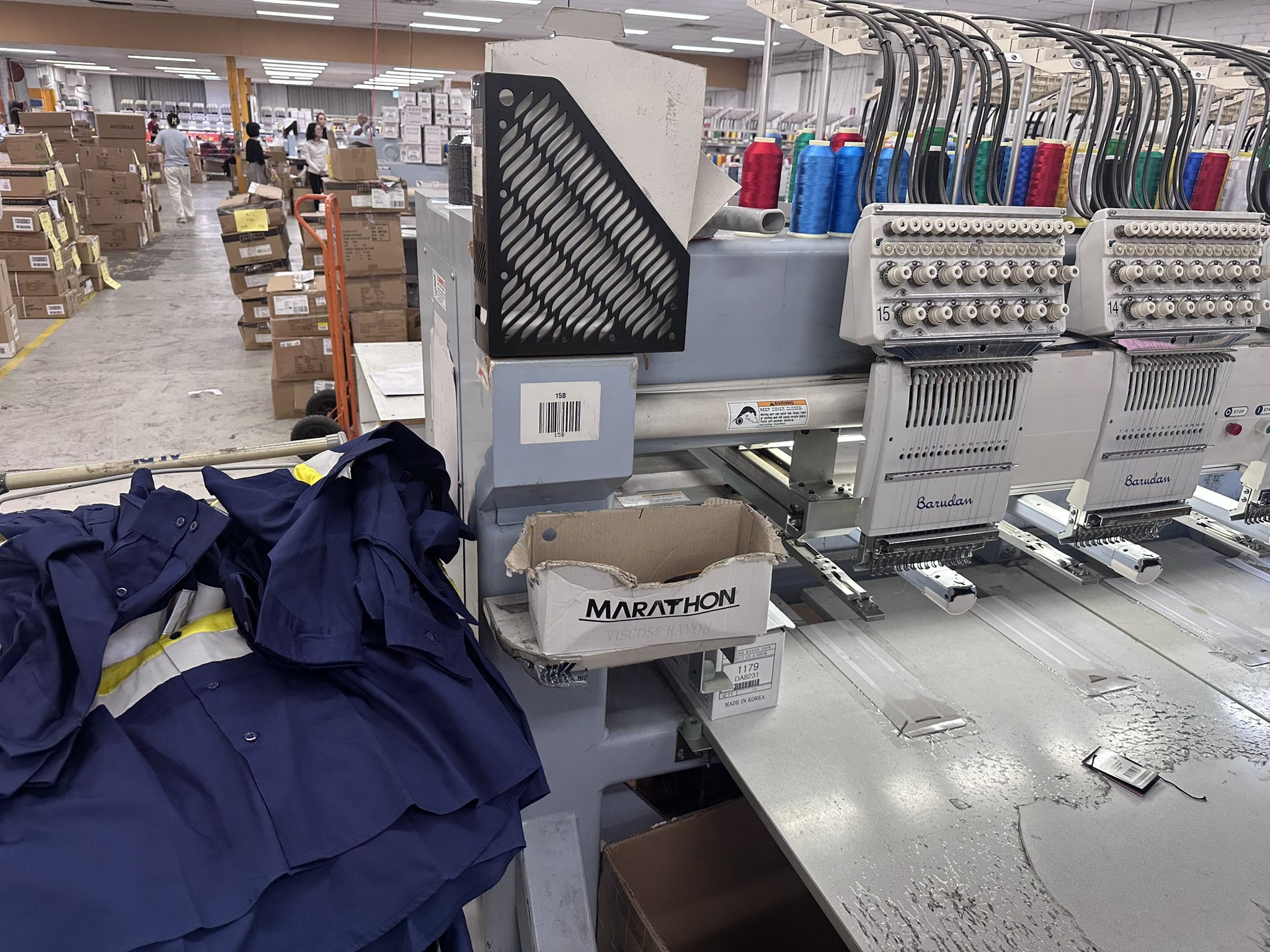Behind the scenes in Australia: Industrial embroidery machines embroider logos on uniforms and boxes.