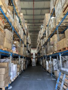 Warehouse aisle with tall shelves, resembling an organized FAQ section of stacked boxes.
