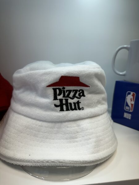 White Pizza Hut bucket hat on display shelf, perfect merch inspiration from top brands.