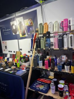 Colorful drinkware and stationery displayed at APPA 2025 expo on shelves and tables.