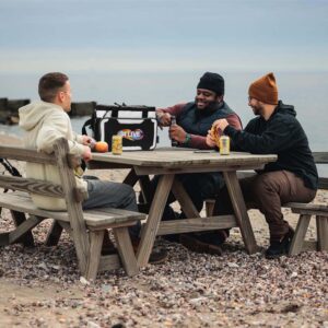 Image of men at a picnic sitting by a wooden table