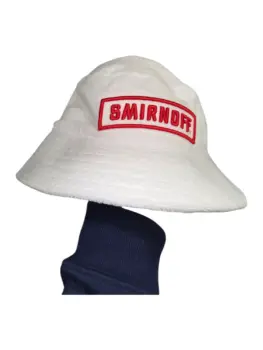 White bucket hat with embroidered SMIRNOFF logo, held up by a person behind the scenes.