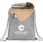 Drawstring backpack with Kodiak Coffee Company logo, holding sunglasses and notebooks.