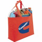 Red tote bag with a Cummins logo, filled with various items including a magazine and drink.