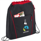 Black and red drawstring bag with Fairtrade logo and magazine in outer pocket.