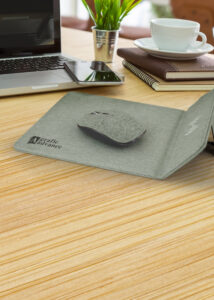 A mouse and a mousepad on a desk, custom branded with corporate logo