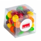 A clear plastic box filled with colorful candy-coated chocolates, featuring a Selkirk label.