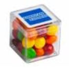 A clear plastic cube filled with colorful candies and a blue label on top.
