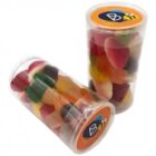 Two clear canisters filled with assorted colorful gummy candies, one lying down.