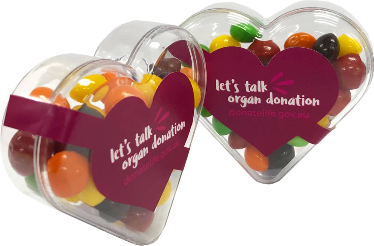 Heart-shaped boxes filled with colorful candy, labeled lets talk organ donation.