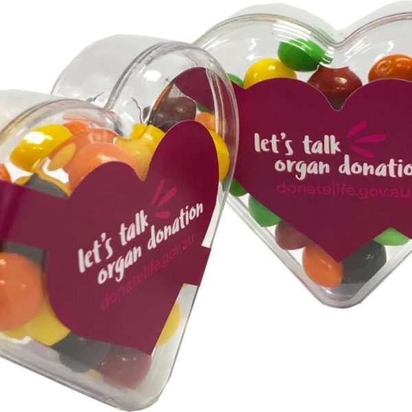 Heart-shaped containers with colorful candies, labeled lets talk organ donation.