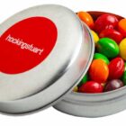 Round metal tin with colorful coated candies and hockingstuart on the red lid.
