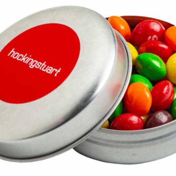 Open tin of colorful candy with hockingstuart logo on the lid.