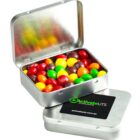 Open metal tin with colorful candies inside and another tin with a black ActivateUTS label.