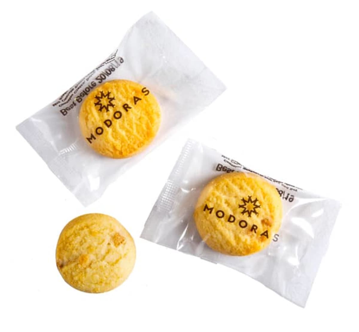 Three round cookies, two in clear wrappers labeled MODORAS, one unwrapped.