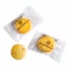 Three yellow, round cookies, two wrapped in clear plastic and one unwrapped.