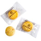 Three round cookies, two in clear MODORAS wrappers and one unwrapped, on a white background.