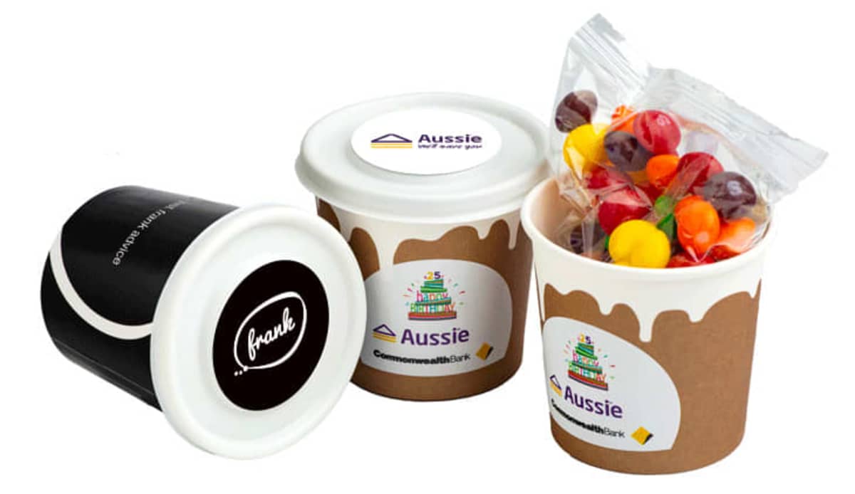 Three branded cups, one filled with colorful candies in a clear bag, on a white background.